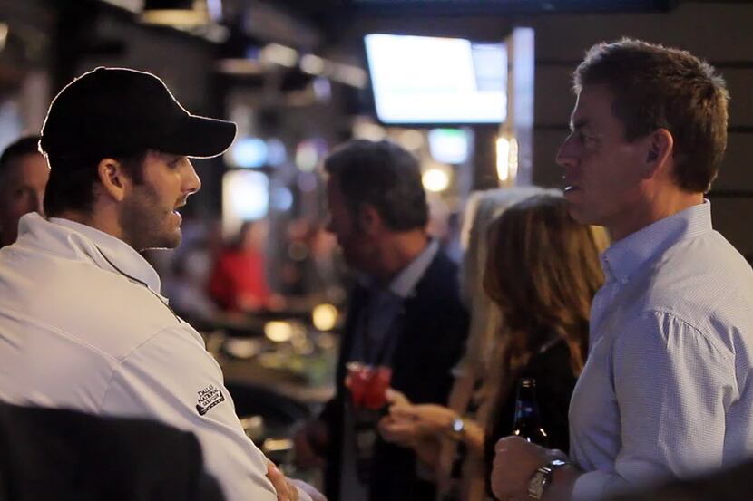 Dallas Cowboys quarterback Tony Romo, left, and former quarterback Troy Aikman talk during...