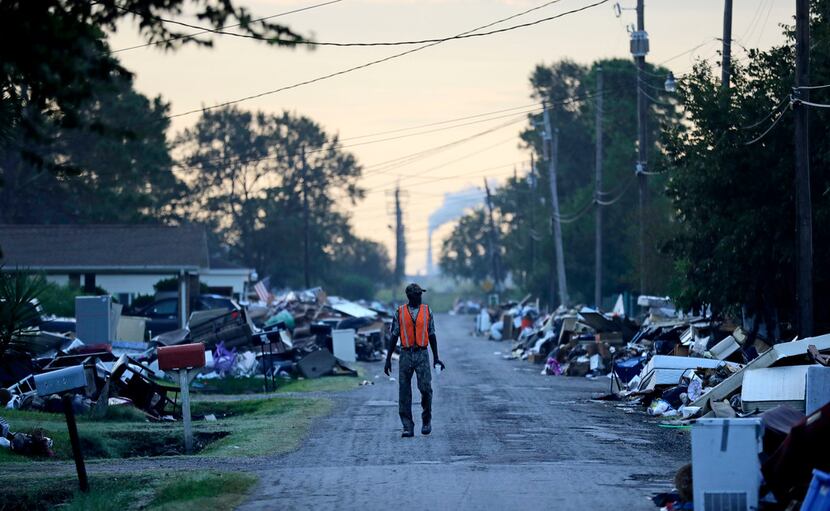 On Sept. 28, 2017, a man walks past debris from homes on his street damaged in flooding from...