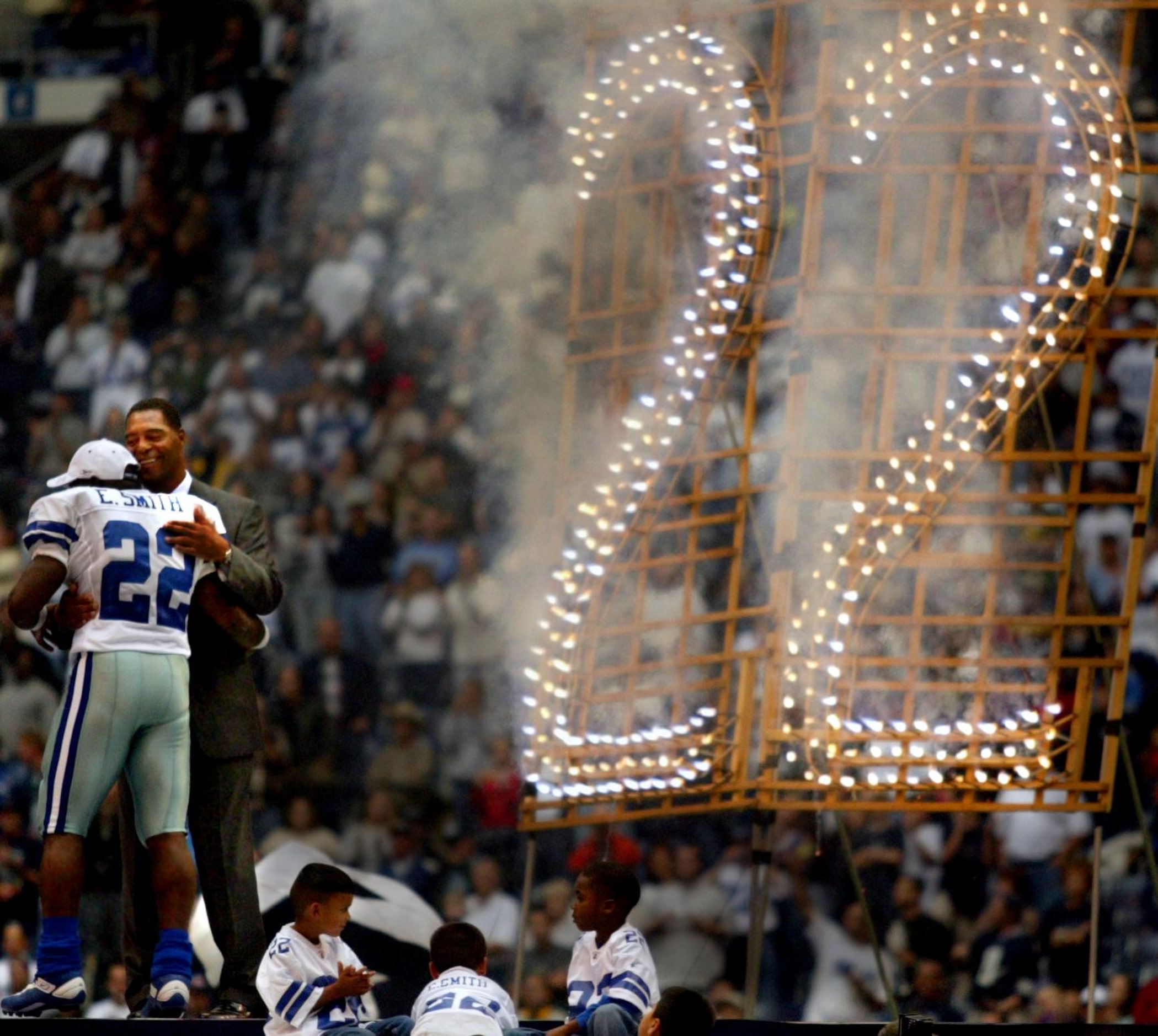 Dallas Cowboys running back Emmitt Smith (22) gets a hug from NFL legend Marcus Allen as he...