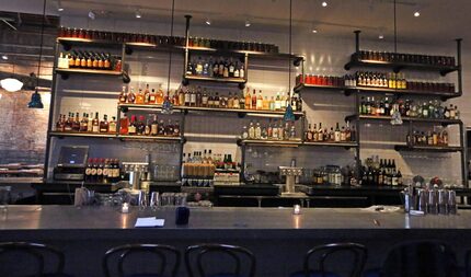 The jars lining the top of the bar are filled with vegetables being pickled.