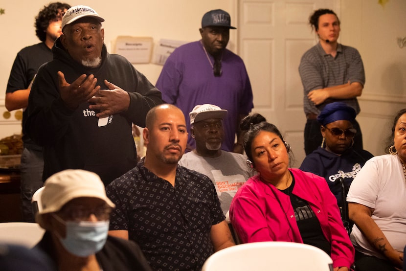 Larry Christopher, 70, left, standing behind Antonio Soto and Celia Soto, asks questions to...