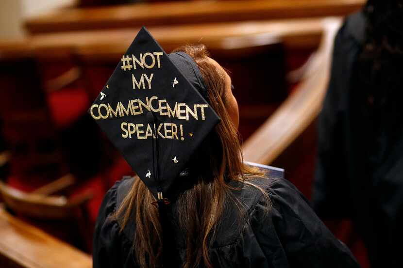 A graduating member of the University of Baltimore wears a message of protest against a...