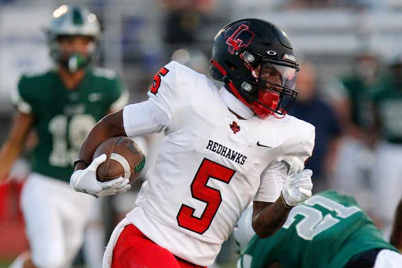 Frisco Liberty wide receiver Evan Stewart carries the football during a game against Frisco...