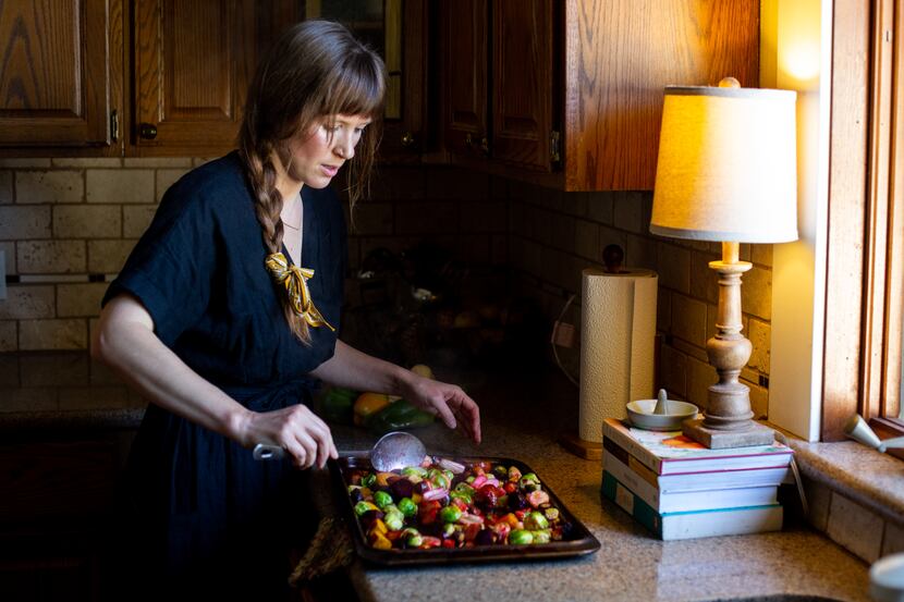 Jade Chessman removes her roasted vegetables from the oven to give them a quick stir before...