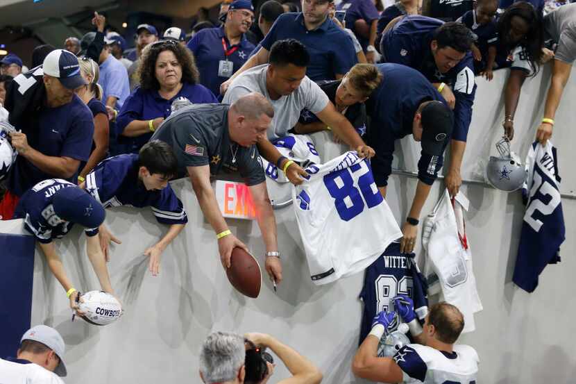 Dallas Cowboys tight end Jason Witten (82) signs items for fans after practice during...