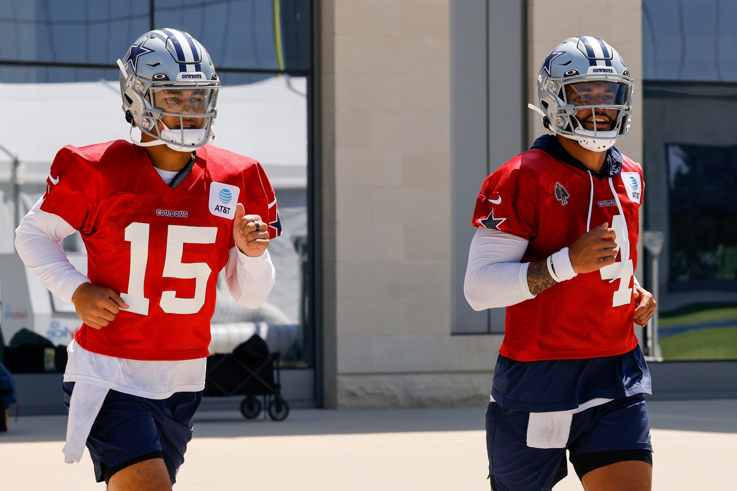 Dallas Cowboys quarterbacks Trey Lance (15) and Dak Prescott (4) jog to the field for a...