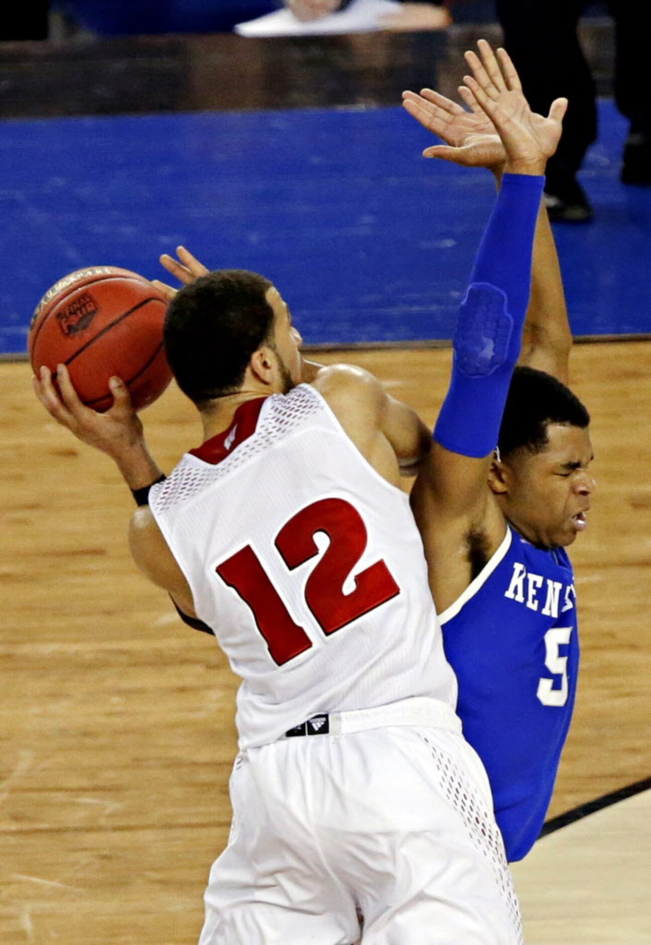 Kentucky Wildcats guard Andrew Harrison (5) fouls Wisconsin Badgers guard Traevon Jackson...