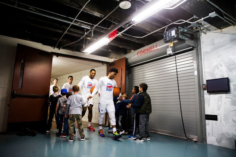 Southern Methodist Mustangs players are greeted by children as they walk from the locker...