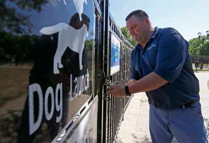 Russell Hooper of the Dallas Park & Recreation Department locks up the gate of the dog...