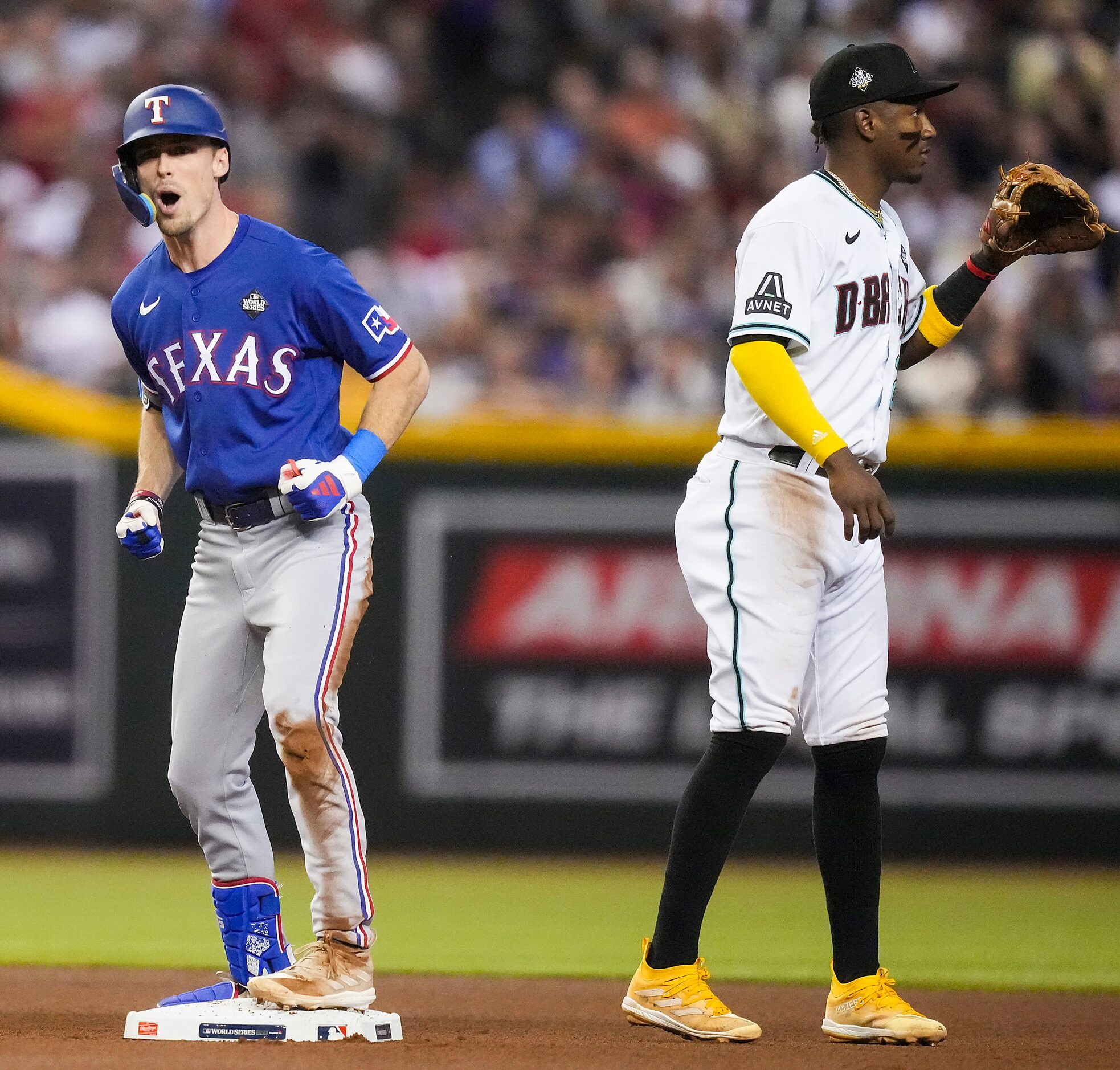 Texas Rangers’ Evan Carter celebrates a double as Arizona Diamondbacks shortstop Geraldo...