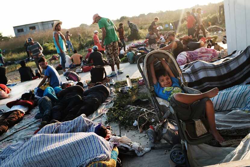 Members of the Central American caravan wake up after spending the night in a camp on Oct....