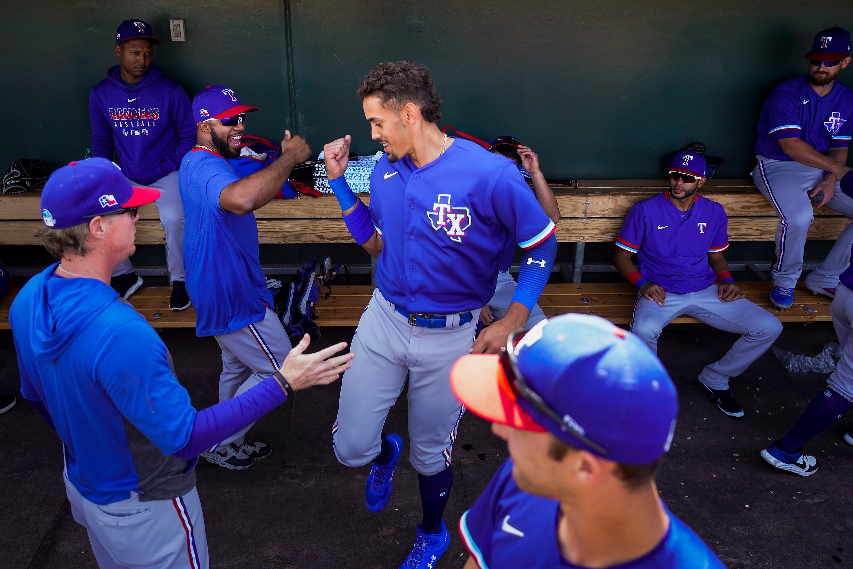 Texas Rangers first baseman Ronald Guzman (center) dances in the dugout with shortstop Elvis...