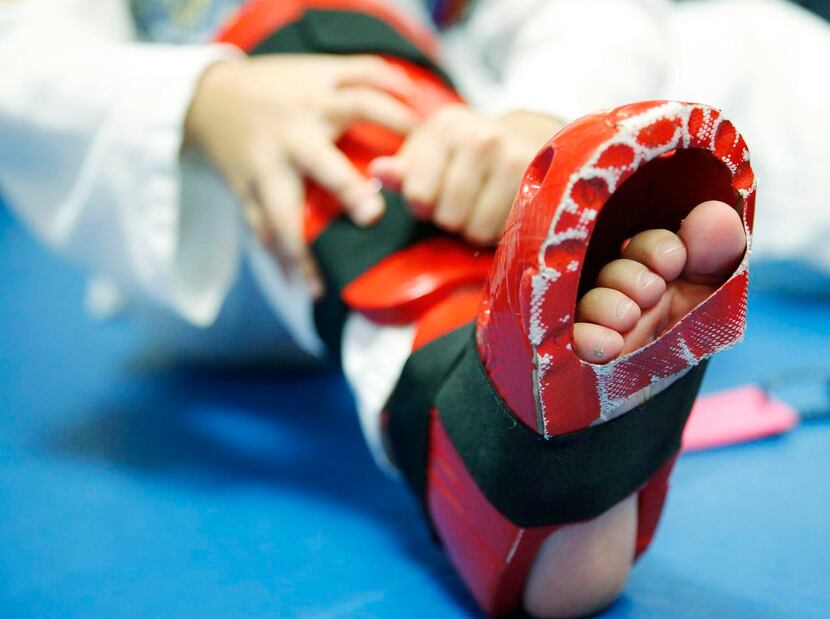 
Evita Nino, 9, puts on pads before practice. The USA Taekwondo National Team is headed to...