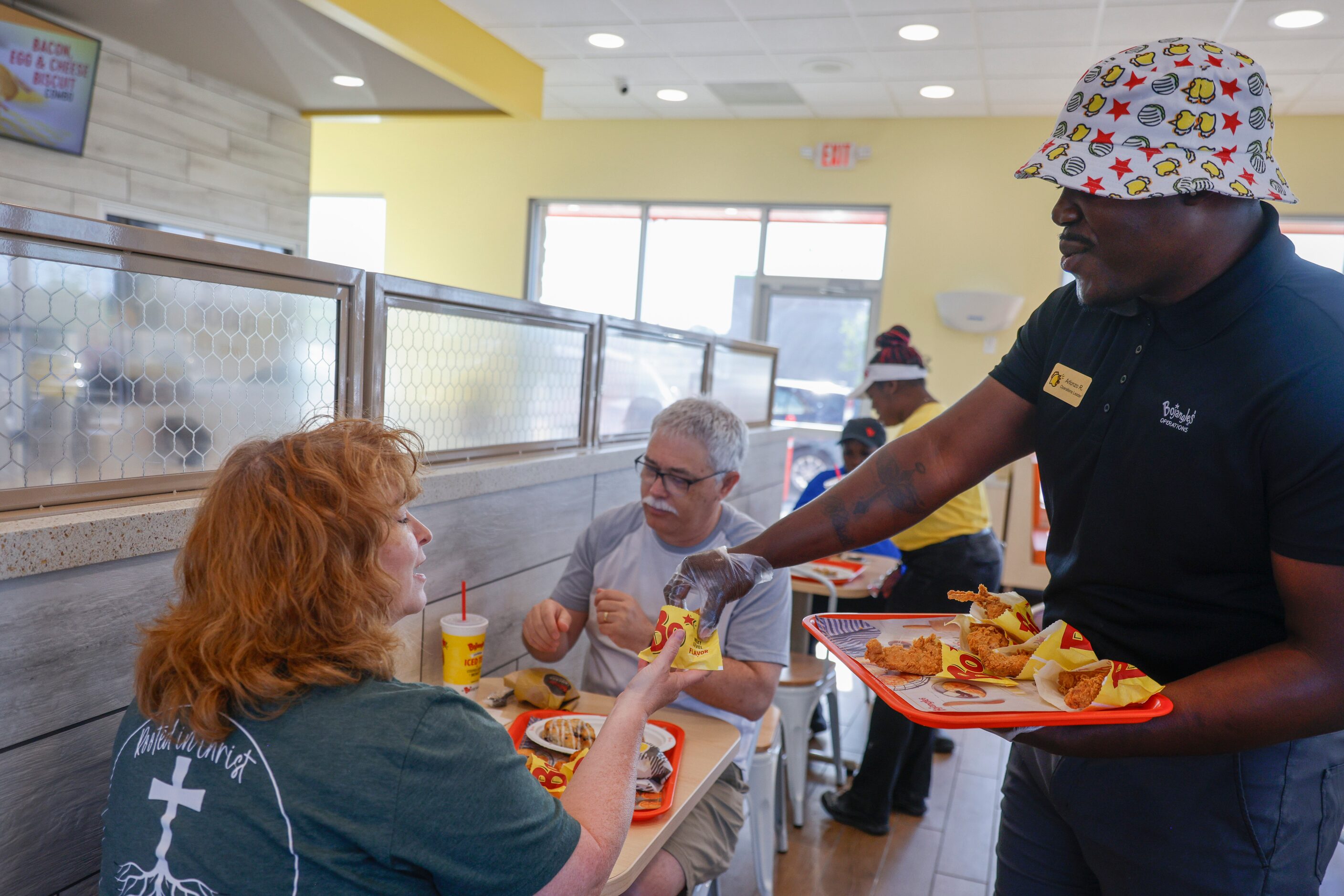 Tina Rosenbaum (left) receives a free chicken tender from operations manager Arlonzo R....