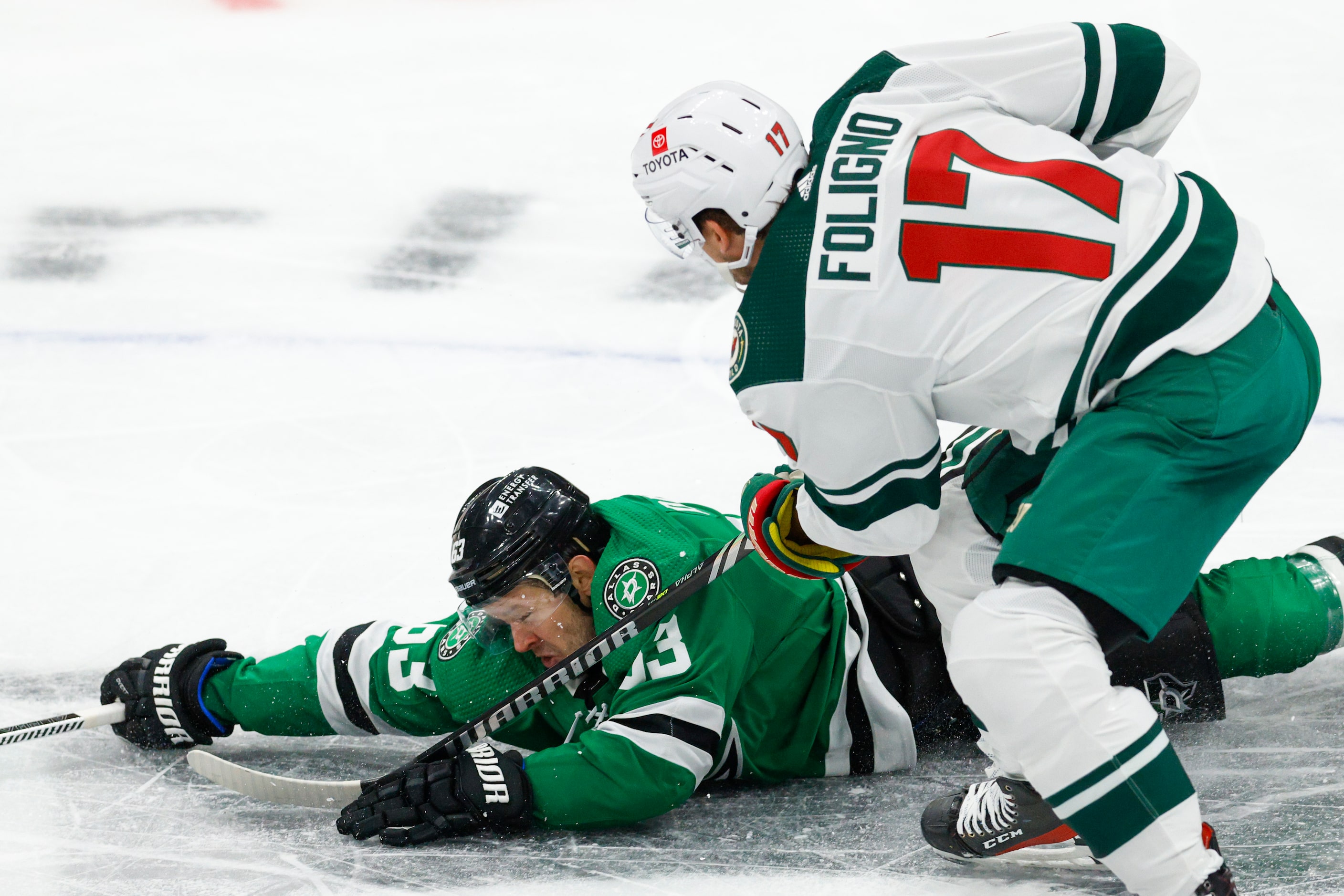 Dallas Stars right wing Evgenii Dadonov (63) falls to the ice as he battles for the puck...