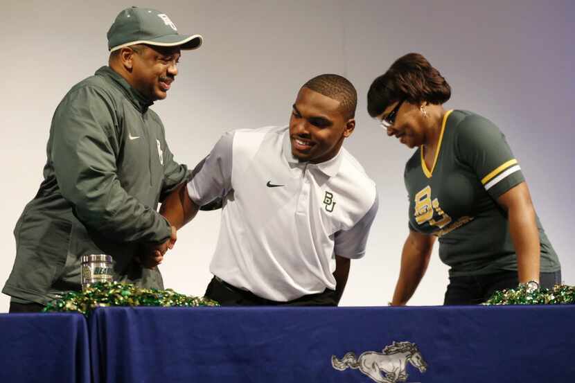 Sachse wide receiver Devin Duvernay is congratulated by his father Henry and mother Zena...