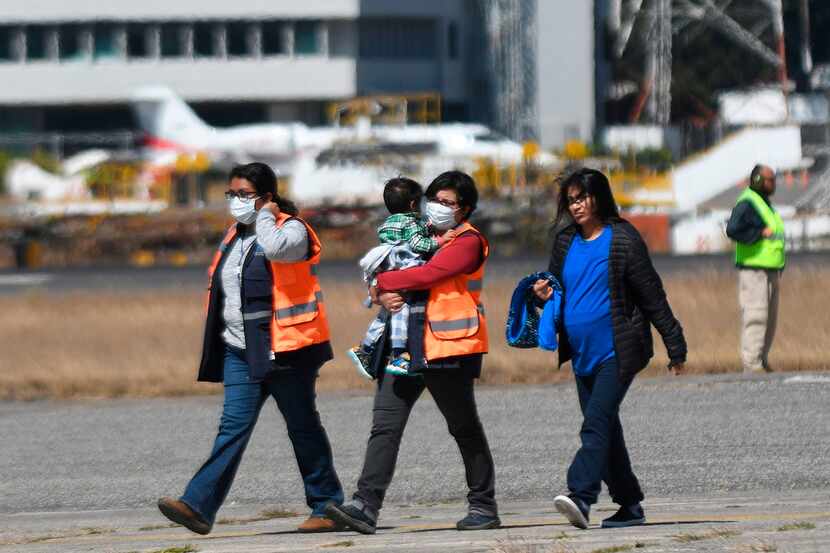 Oficiales de inmigración de Guatemala reciben a inmigrantes deportados en el aeropuerto de...