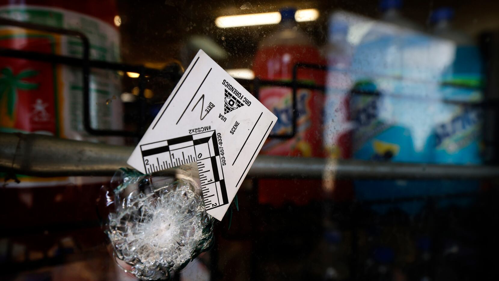 A bullet hole in the Discount Food Mart window is marked at South Westmoreland Road and...