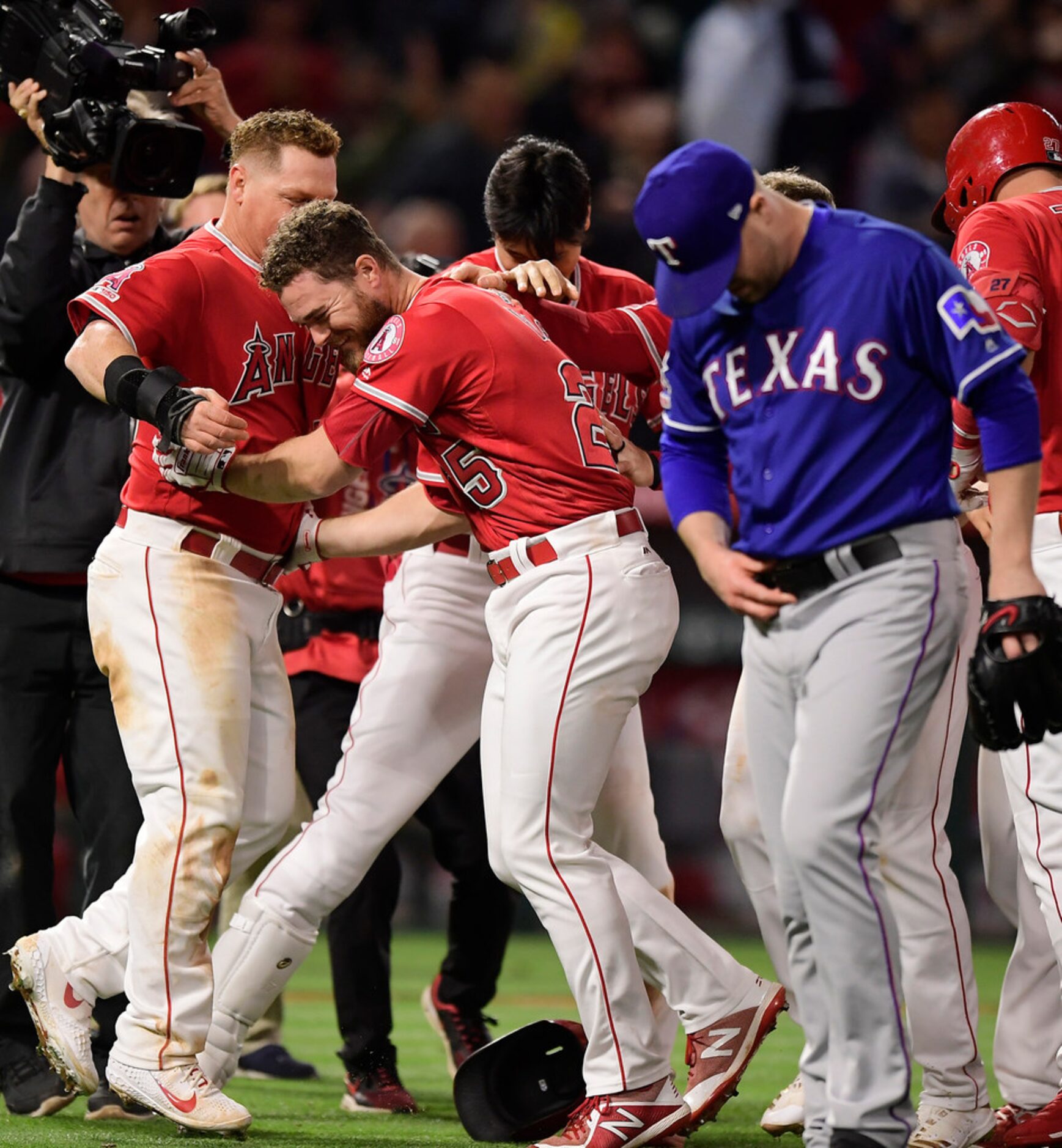 Los Angeles Angels' Jared Walsh, middle, celebrates with Kole Calhoun, left, after Walsh hit...