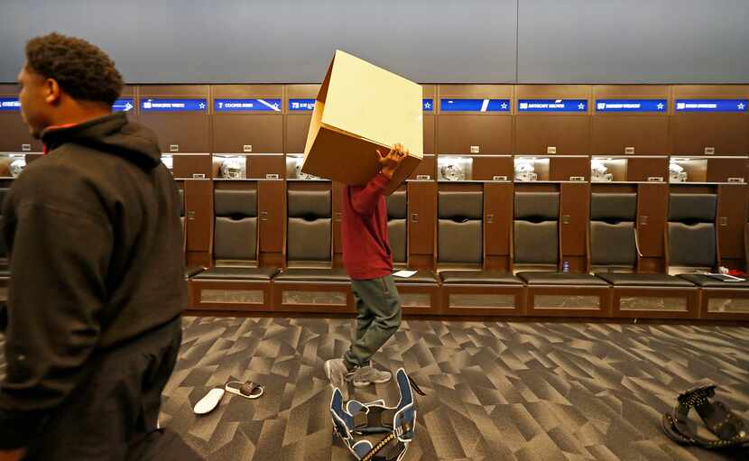 Dallas Cowboys wide receiver Brice Butler carries an empty box as he cleans out his locker...