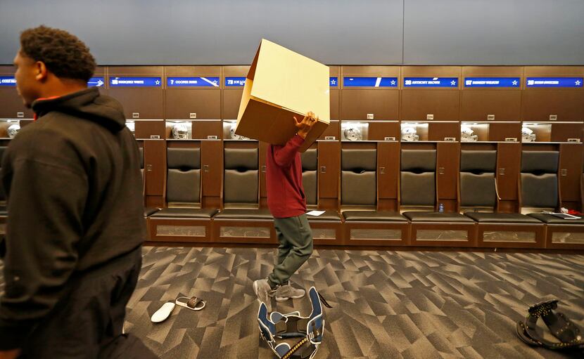 Dallas Cowboys wide receiver Brice Butler carries an empty box as he cleans out his locker...