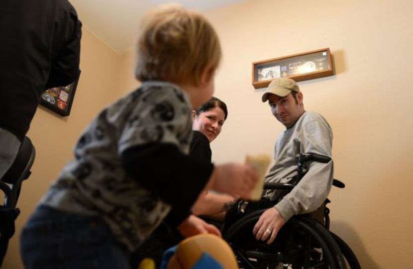 
Colbert and his wife, Emily, share a smile with their son, Deagan, during therapy in their...