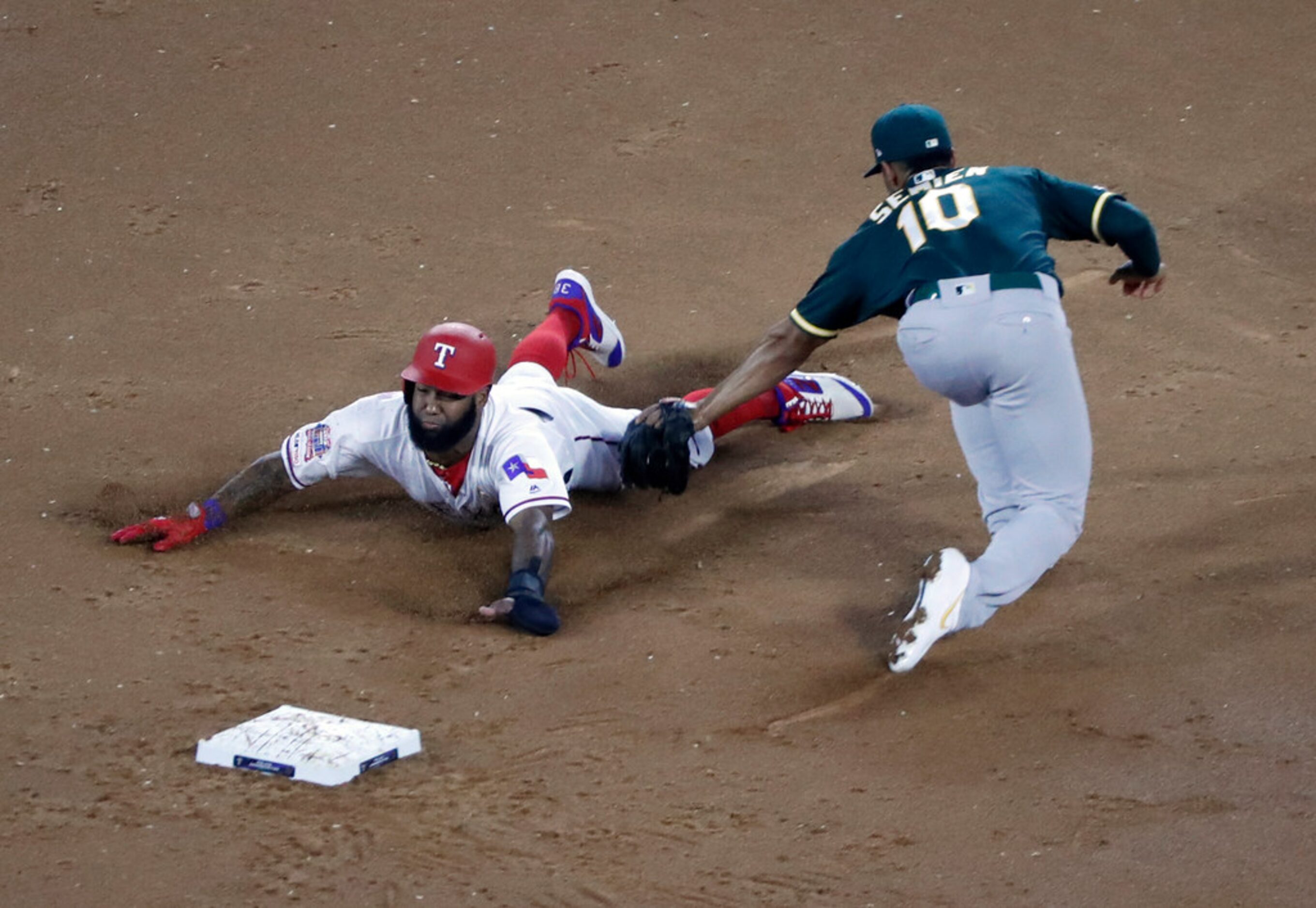 Texas Rangers' Danny Santana steals second under the attempted tag of Oakland Athletics...