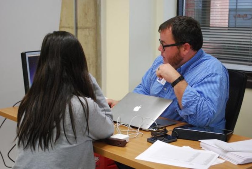 
Kenneth Dunkle, a 10th grade teacher at Academy High School, works with a student during...