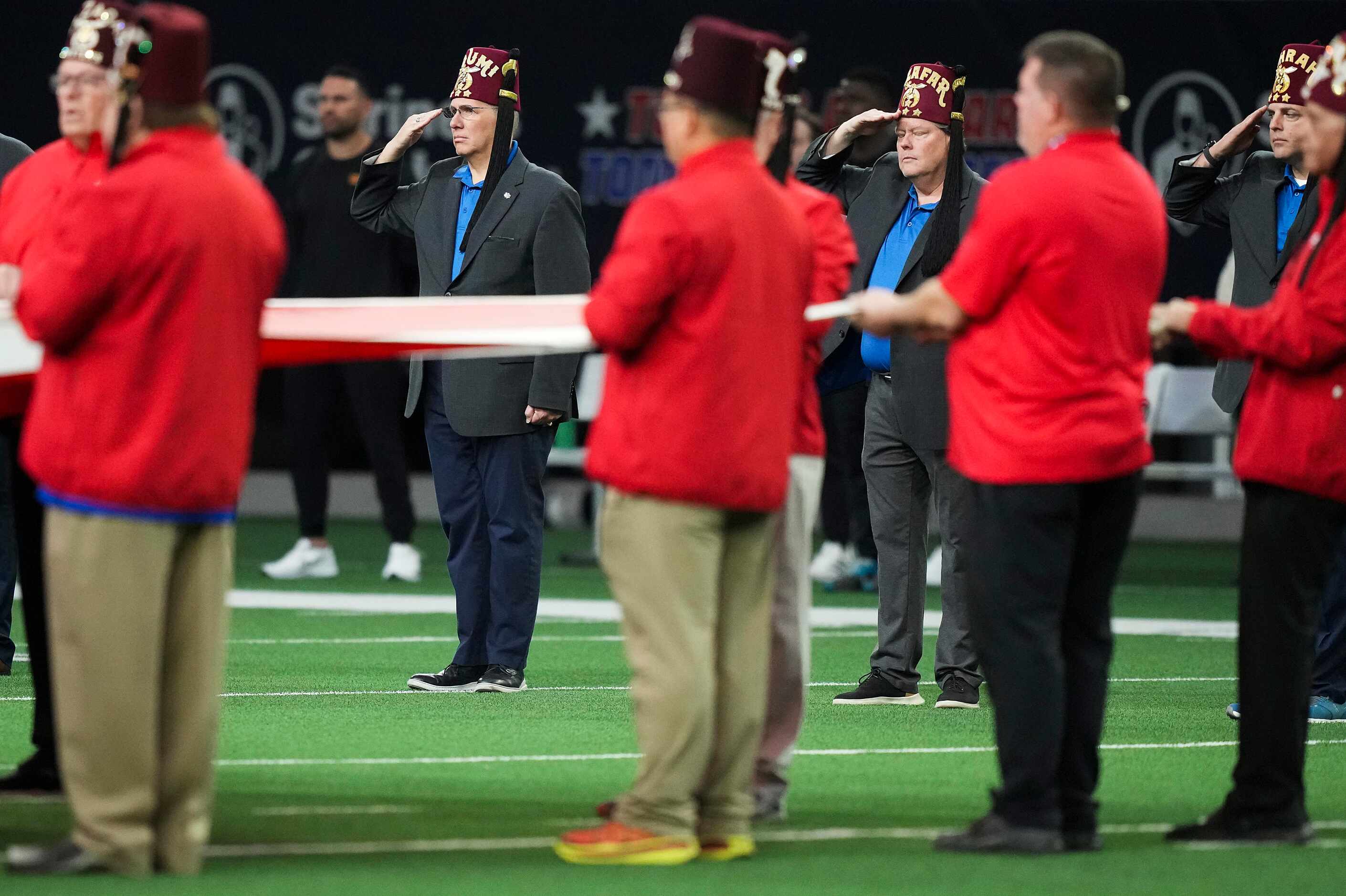 Shriners salute the flag during the national anthem before the East-West Shrine Bowl...