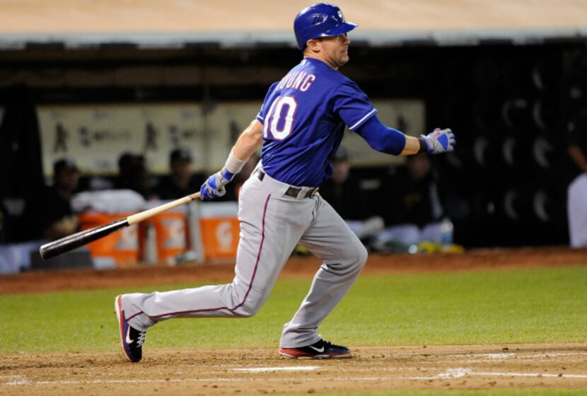 Michael Young #10 of the Texas Rangers hits an RBI single scoring Josh Hamilton #32 against...