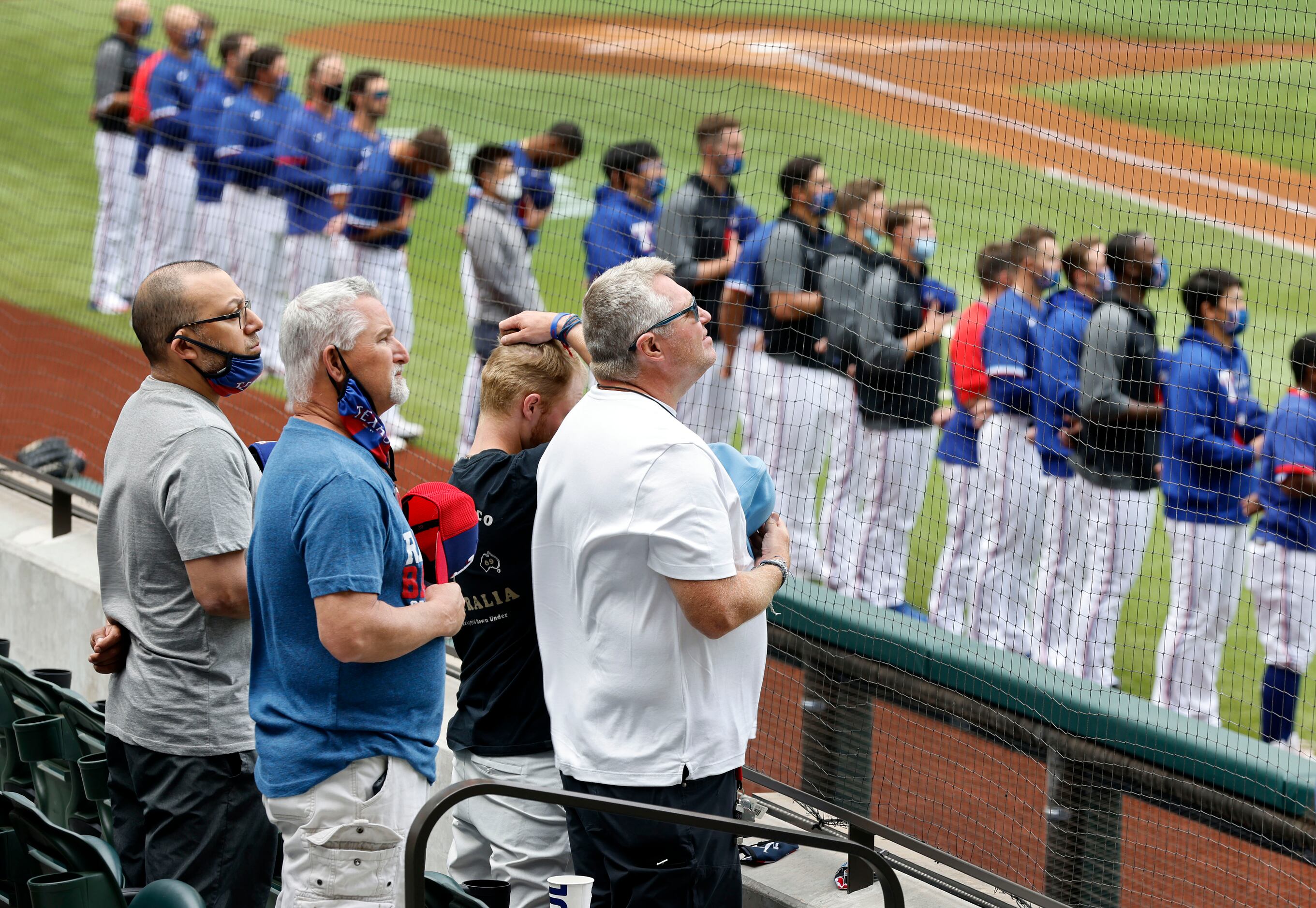 Texas Rangers fans and players stand for the national anthem before their game against the...