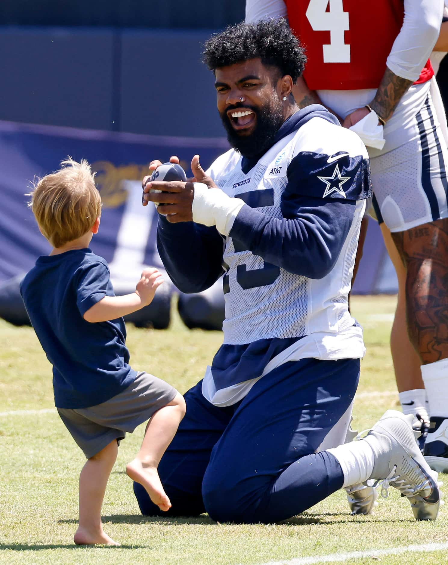 Dallas Cowboys running back Ezekiel Elliott (15) playscyatch with a young boy following...