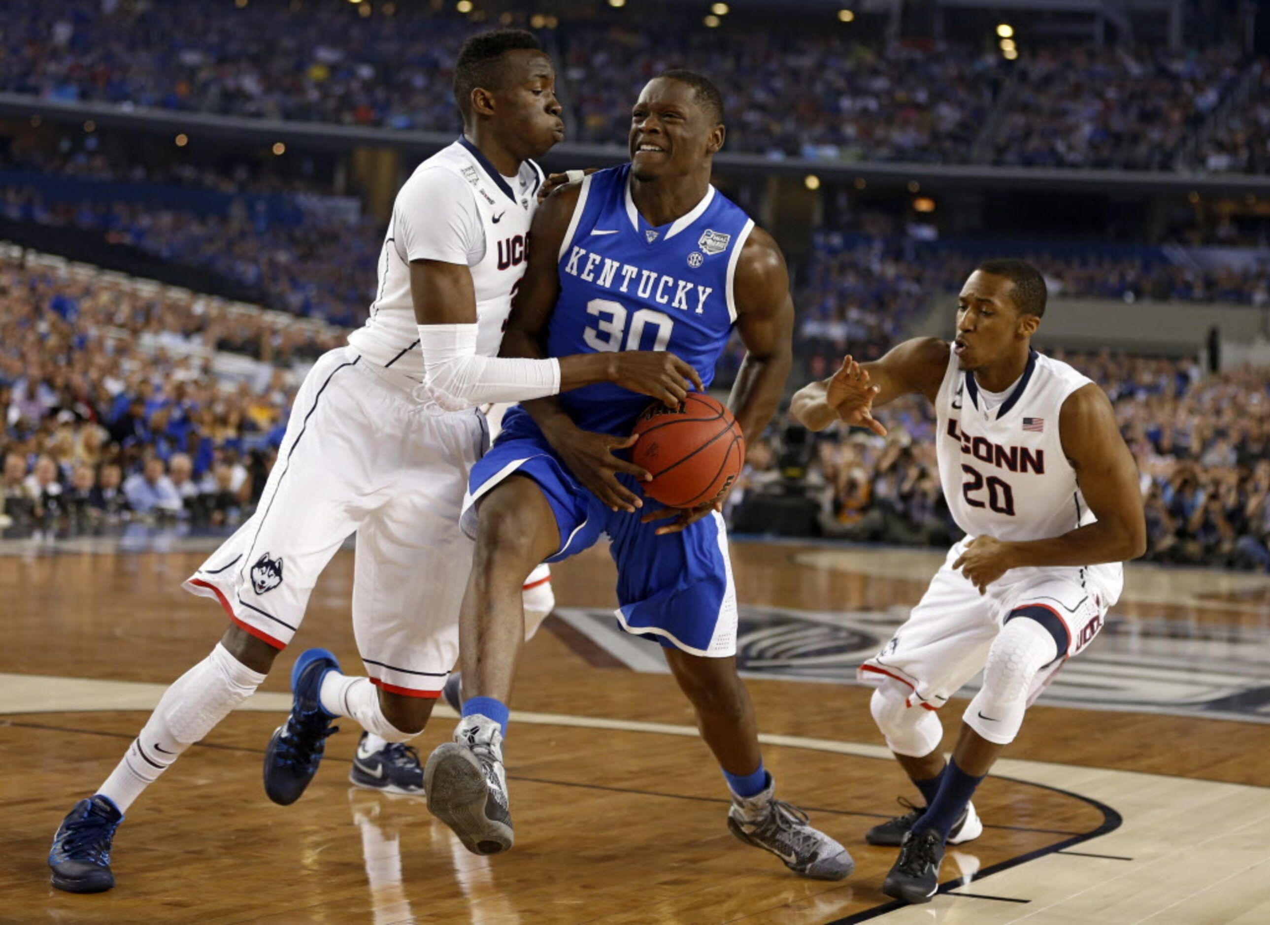 Kentucky Wildcats forward Julius Randle (30) splits Connecticut Huskies center Amida Brimah...