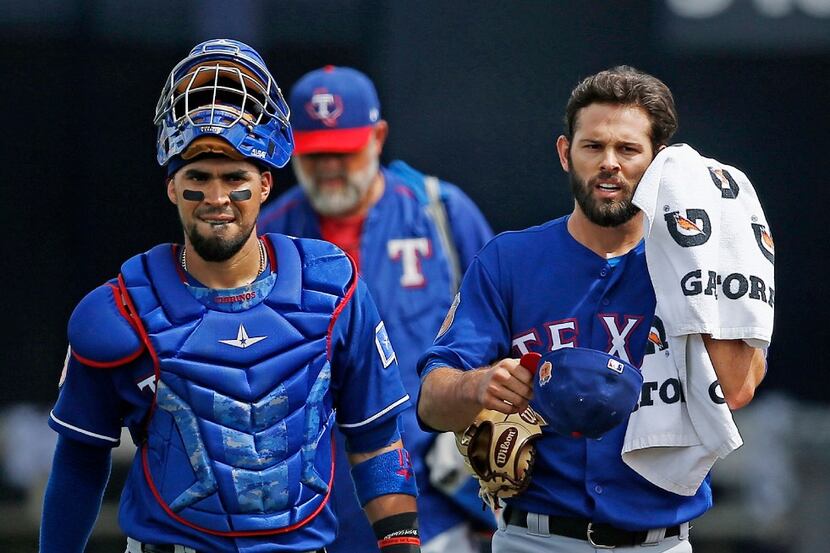 Texas Rangers starting pitcher Nick Martinez, right, walks in from the bullpen with catcher...