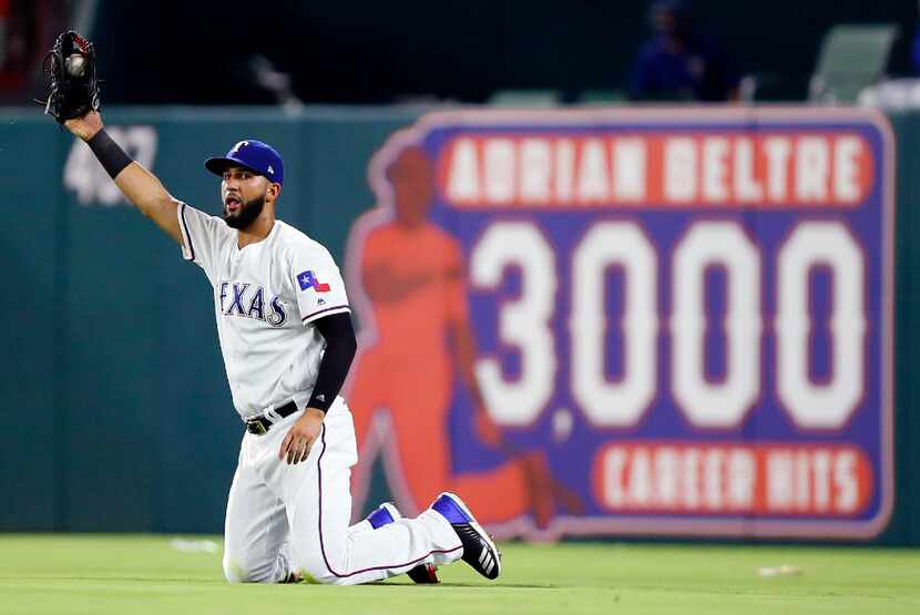 Texas Rangers right fielder Nomar Mazara (30) comes up with a diving catch to end the top of...