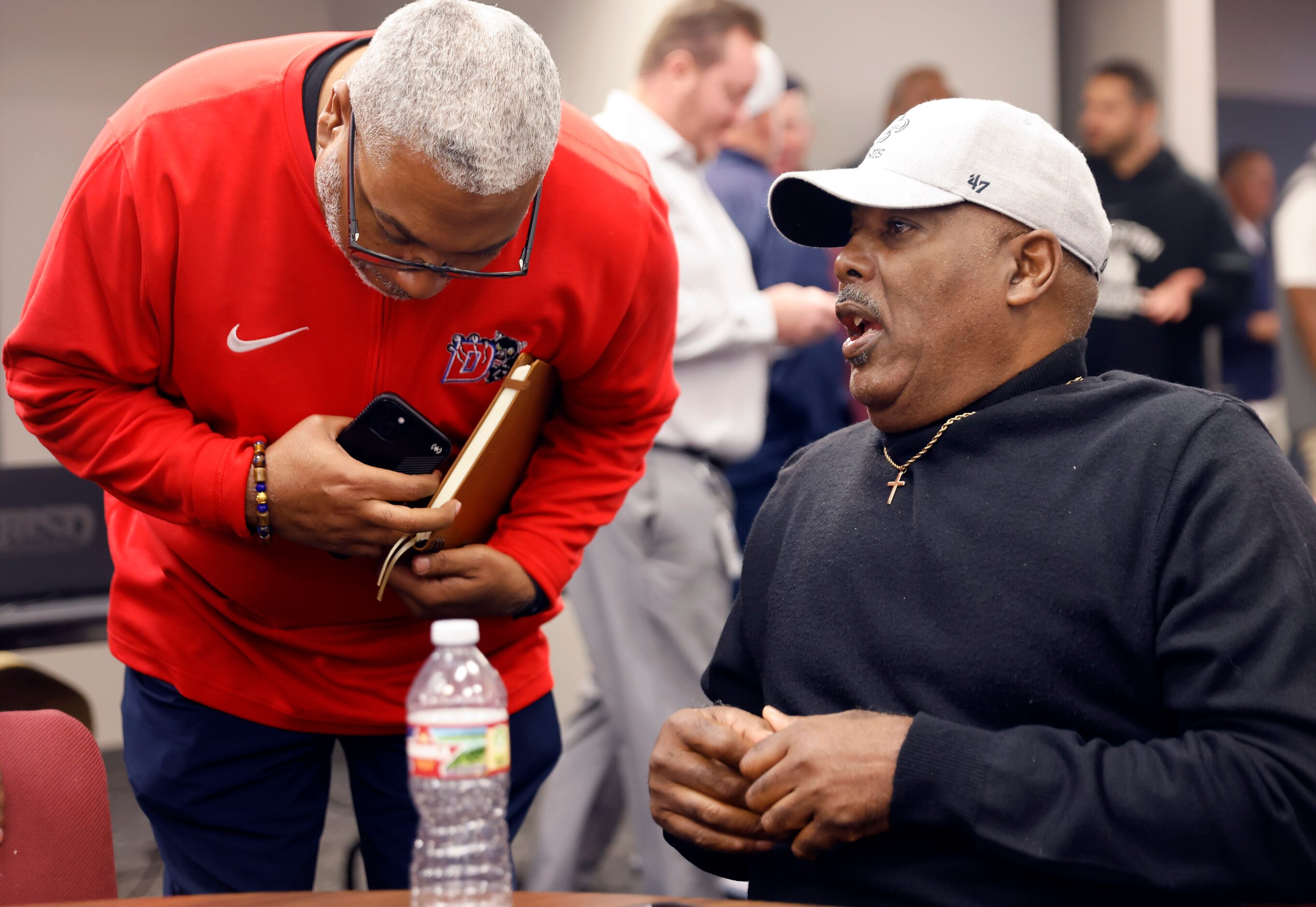 Ducnaville head football coach Reginald Samples (right) visits with his athletic director...