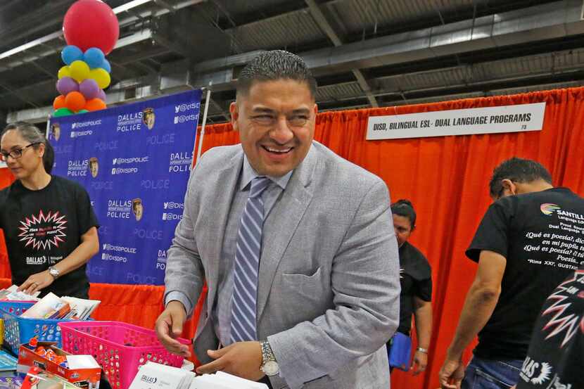 Dallas school board member Jaime Resendez handed out items to parents and students during...