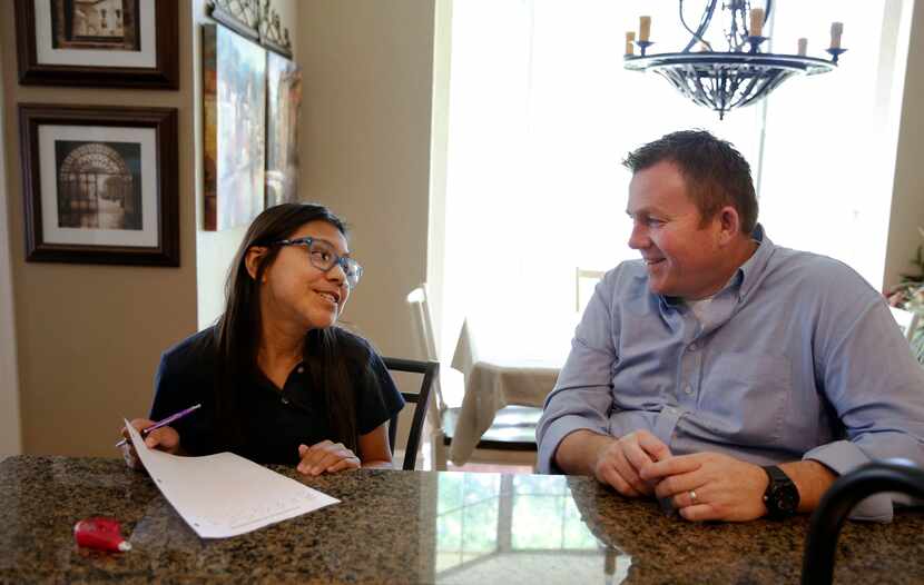 Jason Ballard le ayuda a su hija Emi Ballard a hacer su tarea de matemáticas en su casa en...