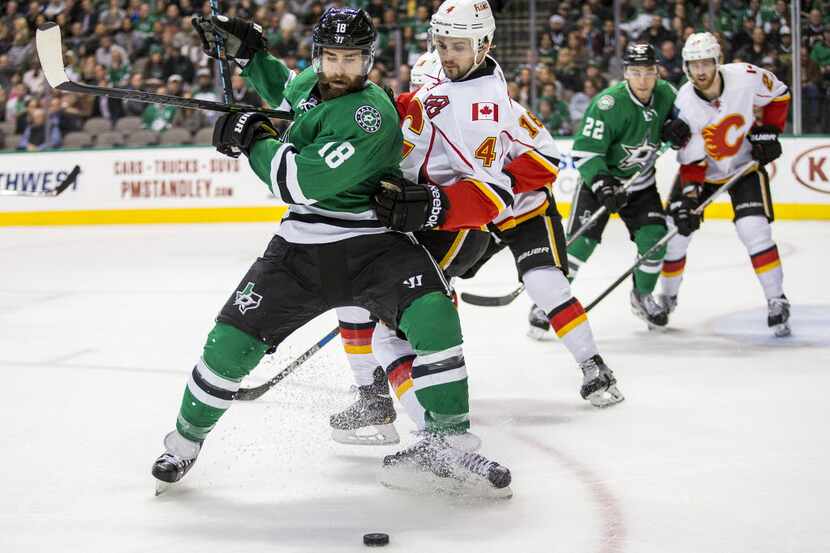 Dallas Stars right wing Patrick Eaves (18) fights for the puck against Calgary Flames...