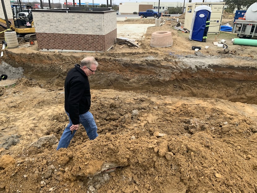 Downwinders at Risk founder Jim Schermbeck inspects mounds of dirt along an open trench on...