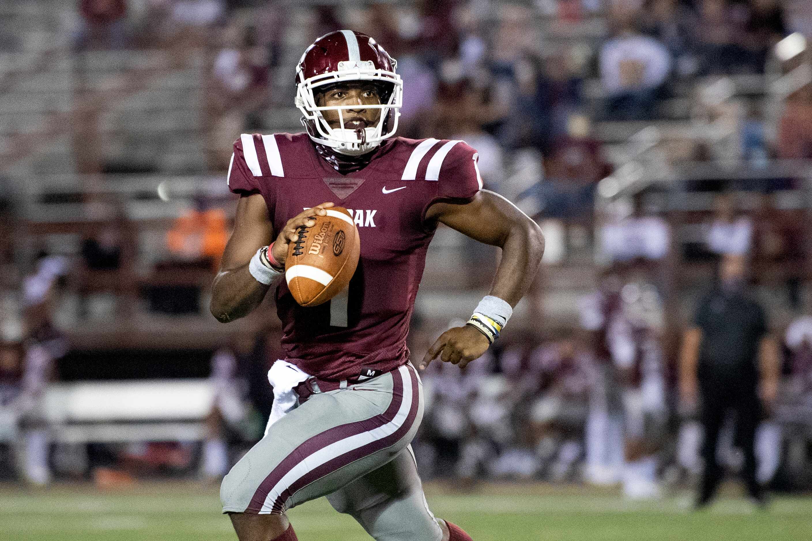 Red Oak sophomore quarterback Chris Parson rolls out of the pocket during the second half of...