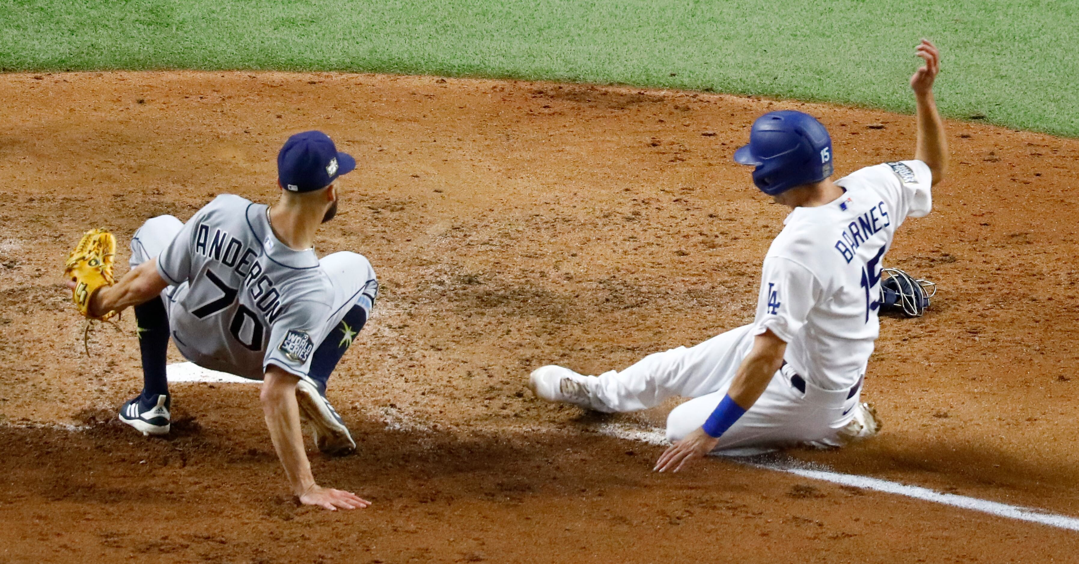 Los Angeles Dodgers catcher Austin Barnes (15) slides safely at home after Tampa Bay Rays...