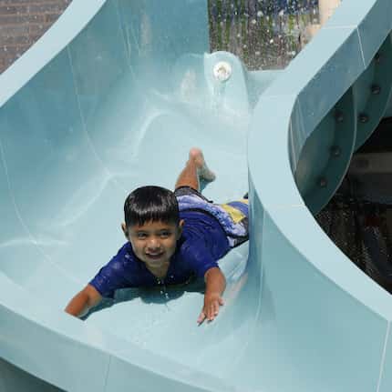 Leo Rodriguez, 3, slides at JadeWaters at the Hilton Anatole in Dallas. 