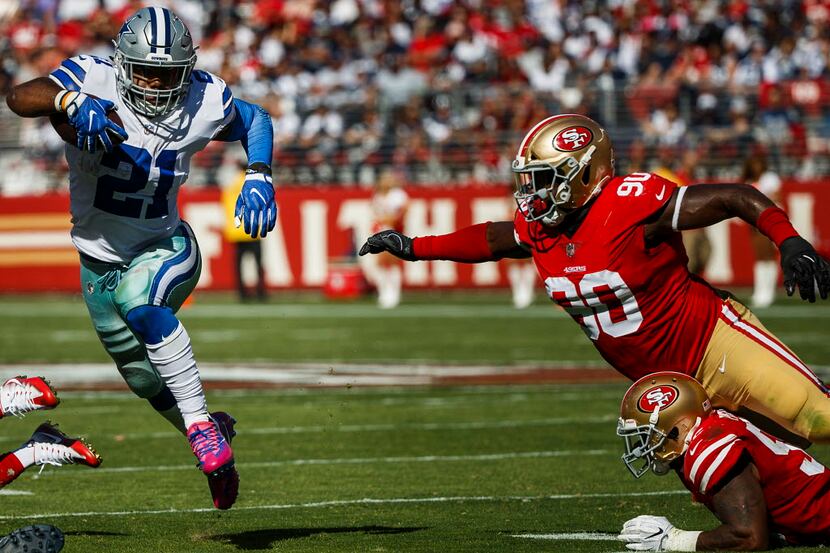 Dallas Cowboys running back Ezekiel Elliott (21) gets past San Francisco 49ers defensive...