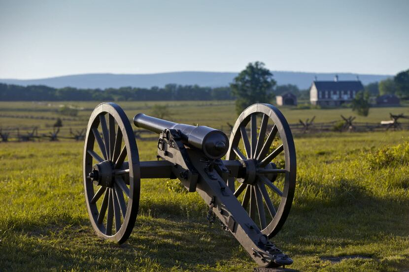 At sunset on the Gettysburg Battlefield, a Union cannon points toward the field where...
