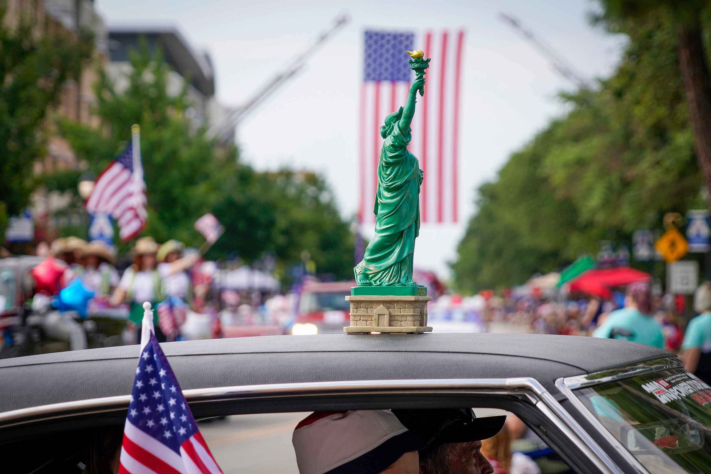 A miniature State of Liberty rides atop a vehicle as members of the Vintage Chevrolet Club...