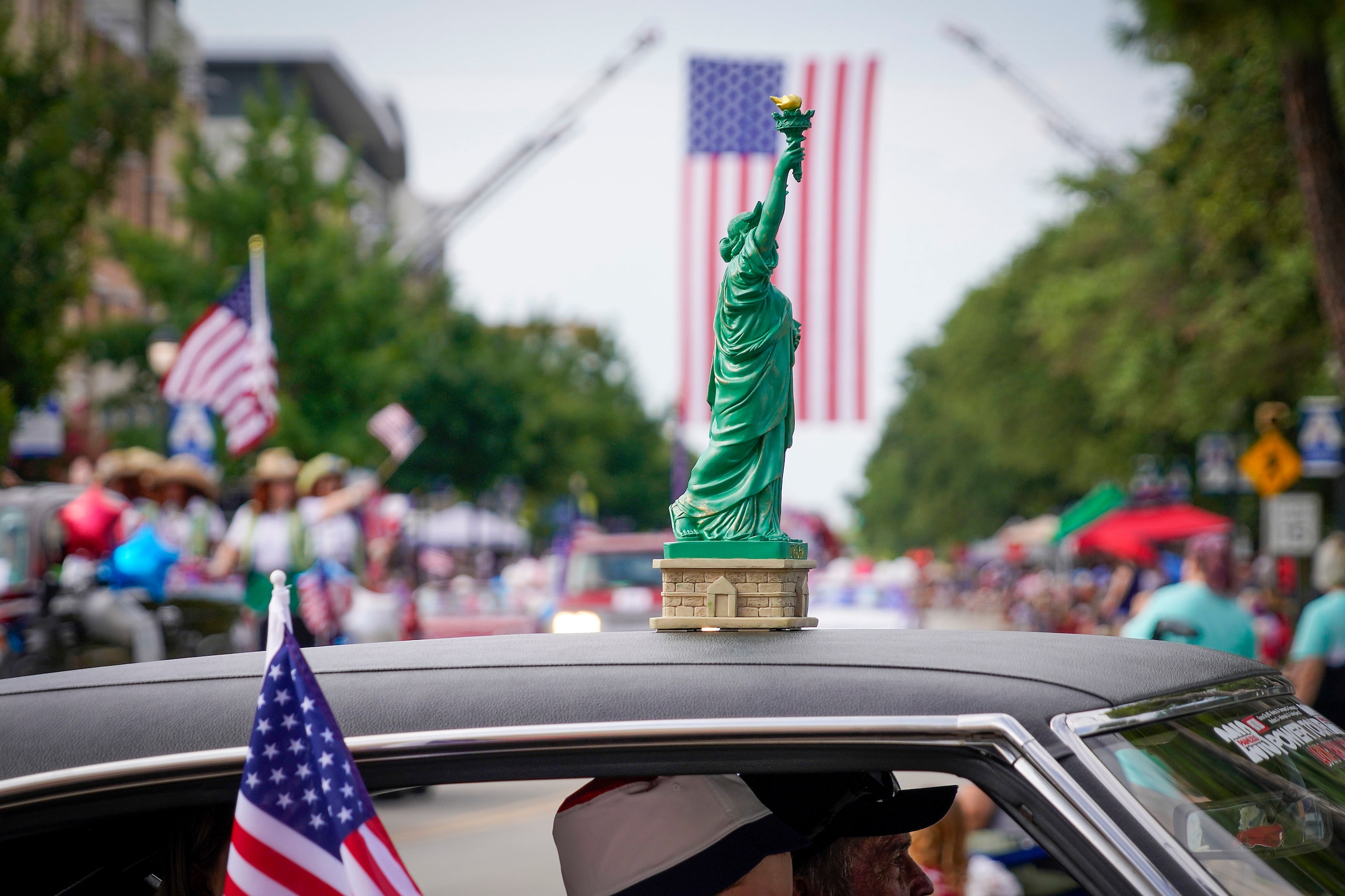 A miniature State of Liberty rides atop a vehicle as members of the Vintage Chevrolet Club...