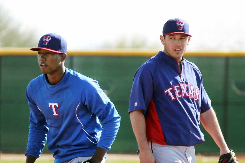 Texas' Jurickson Profar, left, and Ian Kinsler take turns fielding grounders at second base...