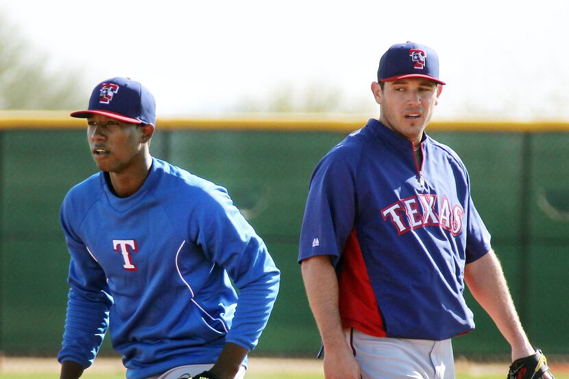 Texas' Jurickson Profar, left, and Ian Kinsler take turns fielding grounders at second base...