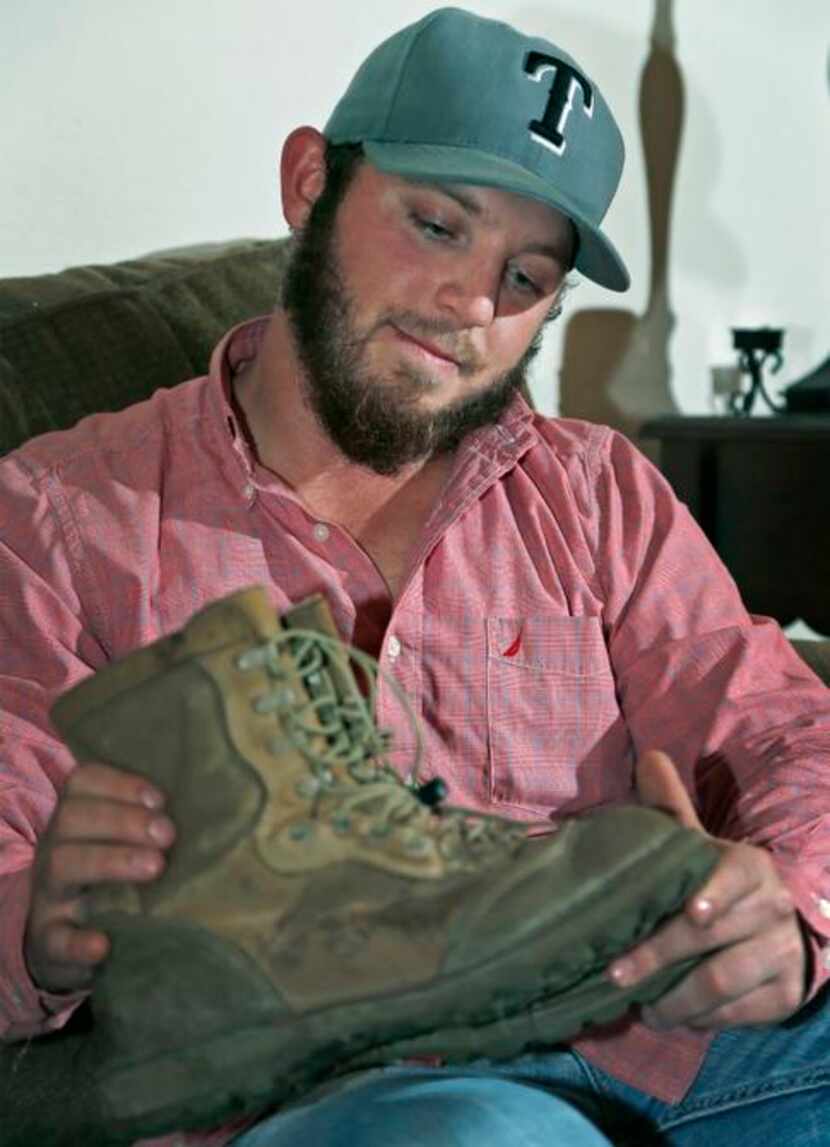 
Dallas resident Adam Saba, 24, looks over the boots he wore in Afghanistan that he keeps at...